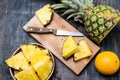 Pineapple on a dark wooden table and pineapple slices on a cutting board Royalty Free Stock Photo