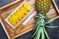 Pineapple on a dark wooden table and pineapple slices on a cutting board Royalty Free Stock Photo