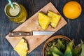 Pineapple on a dark wooden table and pineapple slices on a cutting board Royalty Free Stock Photo