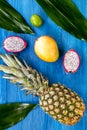Pineapple, dragonfruit and lime on blue wooden desk background top view