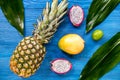 Pineapple, dragonfruit and lime on blue wooden desk background top view