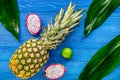 Pineapple, dragonfruit and lime on blue wooden desk background top view
