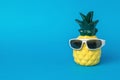 Pineapple figurine in sunglasses on a blue background