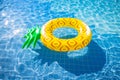 Pineapple float ring on the blue swimming pool Royalty Free Stock Photo