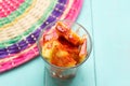 Pineapple cutted with chili powder and piquant sauce in glass on turquoise background Royalty Free Stock Photo
