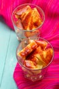 Pineapple cutted with chili powder and piquant sauce in glass on turquoise background Royalty Free Stock Photo