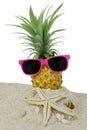 Pineapple fruit and sunglasses on sand Royalty Free Stock Photo