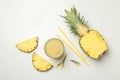 Pineapple, glass of juice, straws and slices on white background