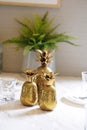 Pineapple. Golden pineapple for house decor interior, on top of dining table with selective focus on the front small pineapple Royalty Free Stock Photo
