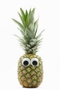 Pineapple with googly eyes on white background