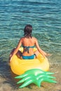 Pineapple inflatable mattress, activity and joy. Summer vacation and travel to ocean. Girl sunbathing on beach with air Royalty Free Stock Photo