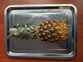 Pineapple on iron tray on wooden table
