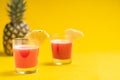 Pineapple juice in glass closeup near sliced fruit with spash and dripping liqid for summer vibes