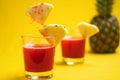 Pineapple juice in glass closeup near sliced fruit with spash and dripping liqid for summer vibes