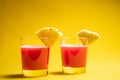 Pineapple juice in glass closeup near sliced fruit with spash and dripping liqid for summer vibes