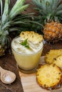 Pineapple juice and pineapple slices cut into pieces on a wooden Royalty Free Stock Photo