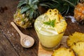 Pineapple juice and pineapple slices cut into pieces on a wooden Royalty Free Stock Photo