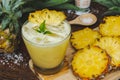 Pineapple juice and pineapple slices cut into pieces on a wooden table. Healthy wood fiber helps to reduce food. Pineapple juice Royalty Free Stock Photo