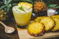 Pineapple juice and pineapple slices cut into pieces on a wooden table. Healthy wood fiber helps to reduce food. Pineapple juice Royalty Free Stock Photo