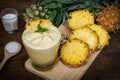 Pineapple juice and pineapple slices cut into pieces on a wooden table. Healthy wood fiber helps to reduce food. Pineapple juice Royalty Free Stock Photo