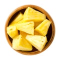 Pineapple pieces in wooden bowl over white