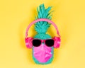 Pineapple in pink headphones and medical mask.