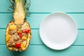 Pineapple rice with chicken and vegetables. Tasty exotic meal and white empty plate. Creative cooking