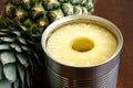 Pineapple rings in tin on dark wood. Royalty Free Stock Photo