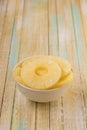 Pineapple rings in a white bowl. Canned ananas slices, copy space