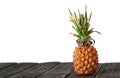 Pineapple stands on wooden boards isolated on white