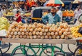 Pineapple trader on big city market and chaos of customers around the busy street