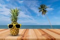 Pineapple on wooden table in a tropical landscape, Fashion hipster pineapple, Bright summer color, Tropical fruit with sunglasses Royalty Free Stock Photo