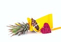 Pineapple with yellow ribbon in paper bag on white isolated background. Festive decor. Royalty Free Stock Photo