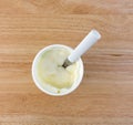 Pineapple yogurt in container with spoon on table