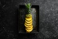 Pineapples in a metal box on a black stone background. Ripe baby pineapple. Tropical fruits. Royalty Free Stock Photo