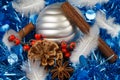 Pines cones, cinnamon sticks, star anise, feather and silvery Christmas ball on a blue tinsel Royalty Free Stock Photo