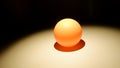 Ping pong ball on dark background with shadows