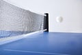 Ping-pong match concept with ball in motion on blue table Royalty Free Stock Photo