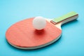 Ping pong paddle with ball on blue. Table tennis racket Royalty Free Stock Photo
