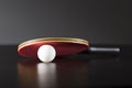 Ping pong racket and ball on dark table