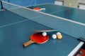 Ping pong rackets and balls on game table with net Royalty Free Stock Photo