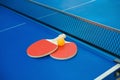 Pingpong rackets and ball and net on blue pingpong table Royalty Free Stock Photo