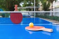 Pingpong rackets and ball and net on blue pingpong table Royalty Free Stock Photo