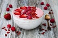 Pink acai, maca powder smoothie bowl topped with sliced strawberries, raspberries and goji berries.