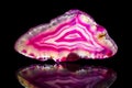 Pink agate slice, black background, healing stone and mineral Royalty Free Stock Photo