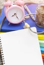 Pink alarm clock closeup standing on pile of books. Business Royalty Free Stock Photo