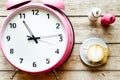 Pink alarm clock on wooden table with coffie top view Royalty Free Stock Photo