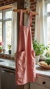 Pink apron hanging in bright rustic kitchen with plants and brick wall Royalty Free Stock Photo