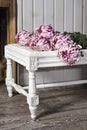 Pink artificial dahlia lying on white table