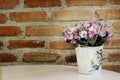 Pink artificial flower on cement brick wall